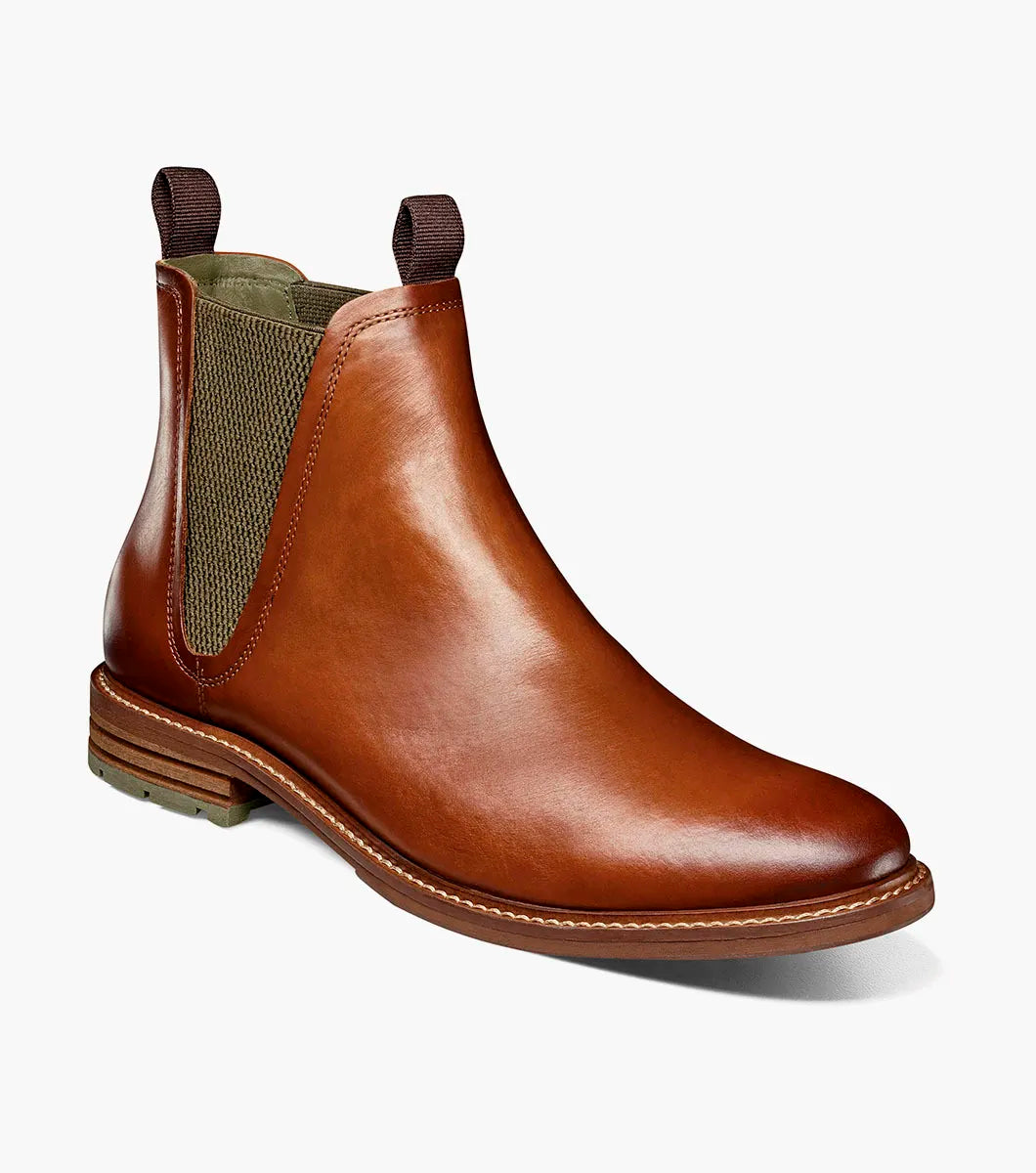 The Stacy Adams Isaacson Plain Toe Chelsea Boot in Cognac features elastic side panels, pull tabs, a low stacked heel, and a supportive leather upper—all displayed on a white background.