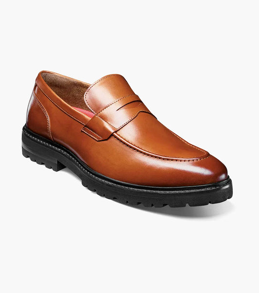 The Stacy Adams Hayes Moc Toe Penny Slip On in tan features anatomical arch support and a black EVA sole, shown here as a single brown leather loafer on a white background.