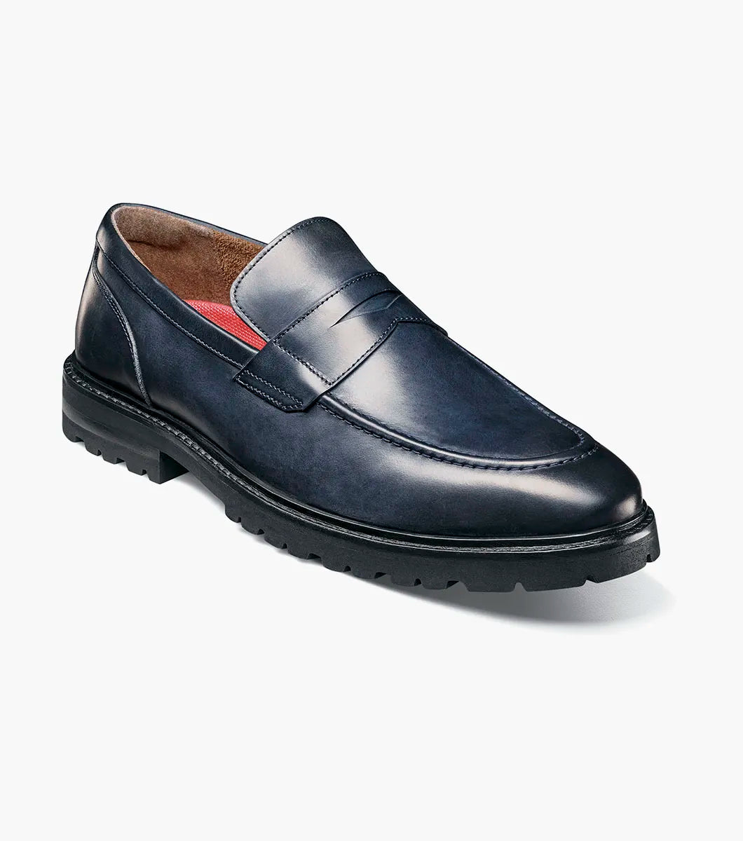 The Stacy Adams Hayes Moc Toe Penny Slip On in navy features a dark blue leather upper, textured black EVA sole, classic penny slot, subtle stitching, and a comfortable RedZone footbed.