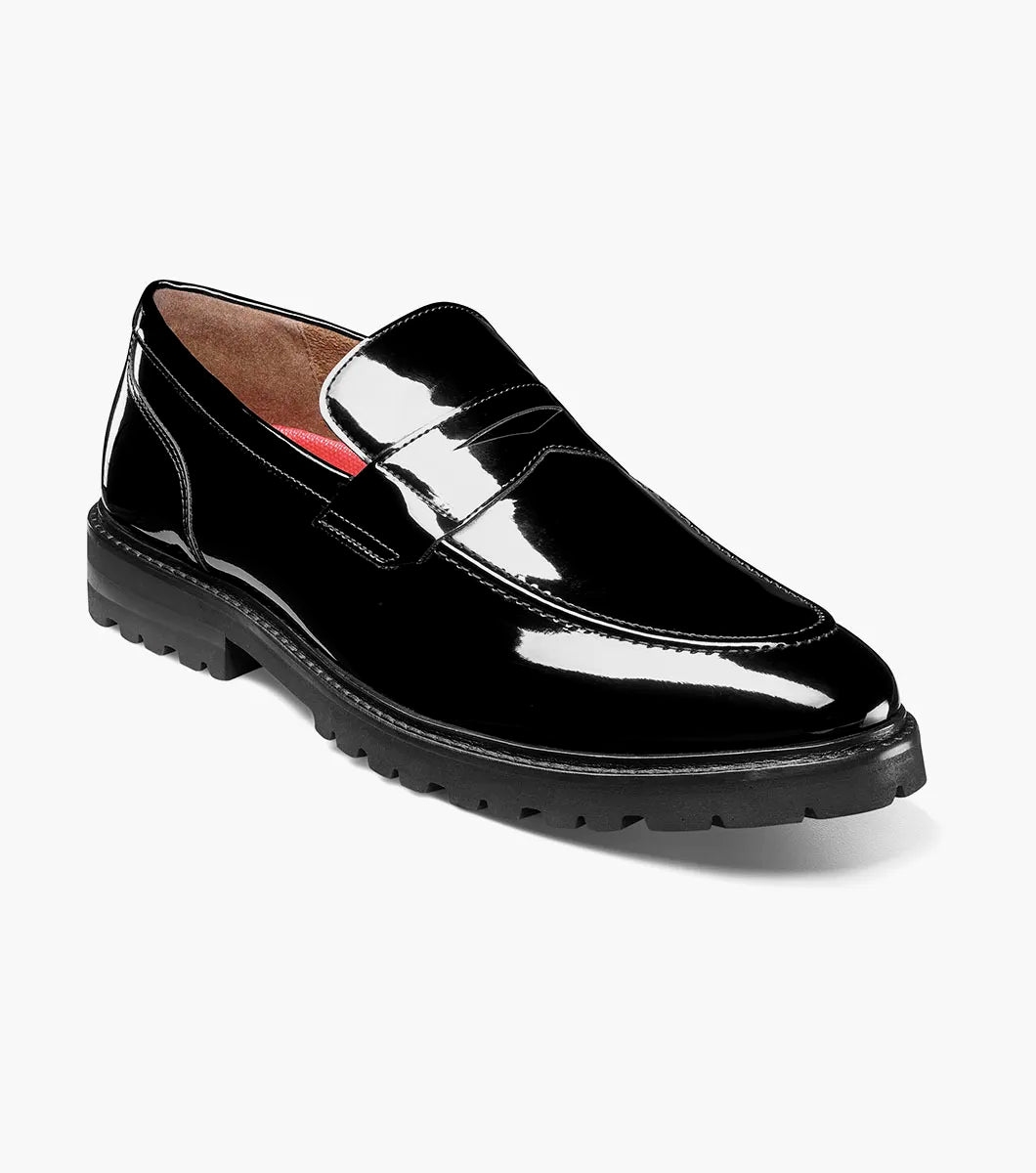 The Stacy Adams Hazelton Moc Toe Penny Slip On (25736-004) in black patent leather features a low heel, thick rubber sole, and RedZone footbed, shown on a white background.