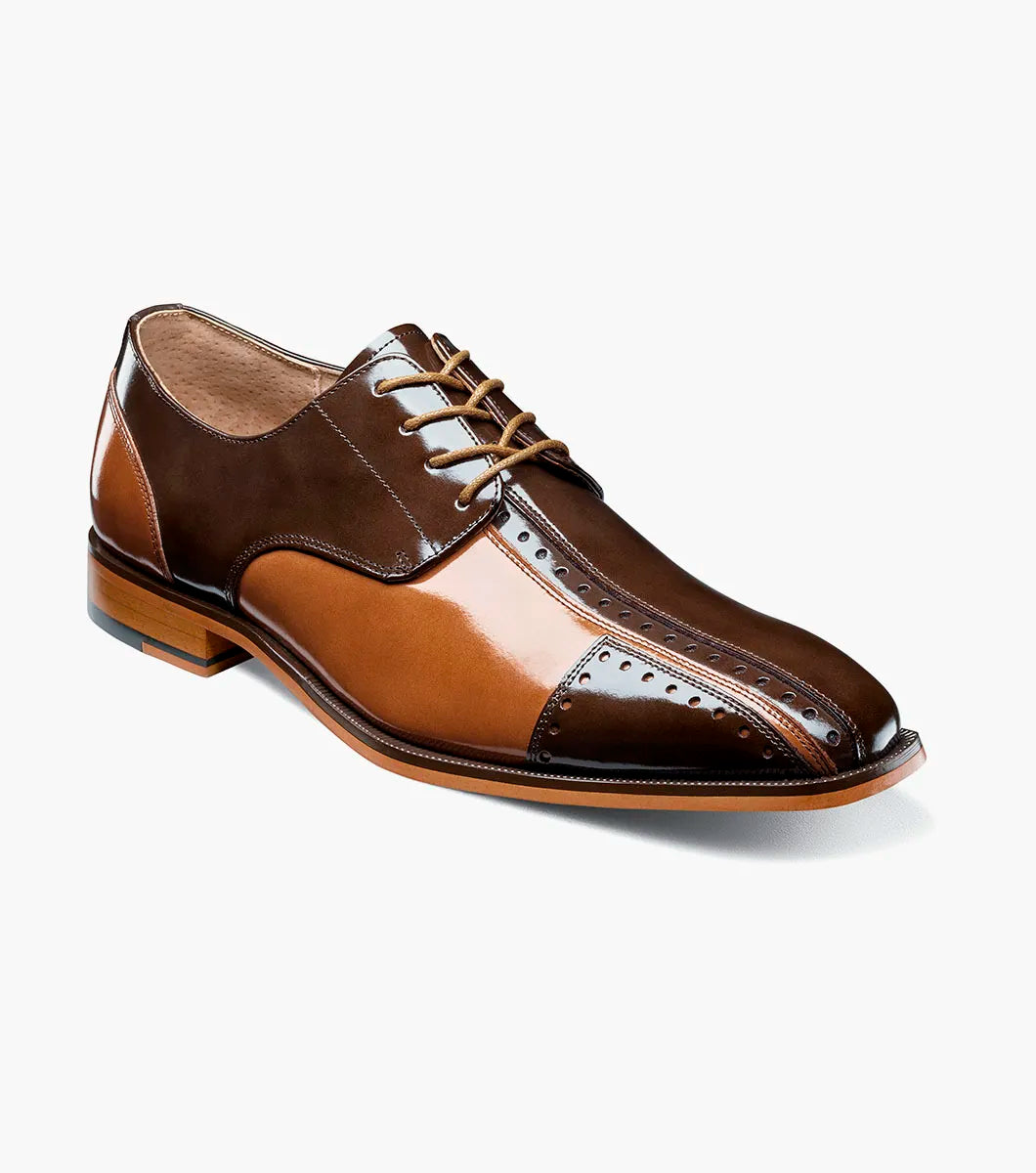 The STACY ADAMS Palmento Modified Cap Toe Oxford (Brown Multi, 25740-249) features a two-tone glossy leather upper, lace-up closure, perforated cap toe detail, and a low wooden heel.