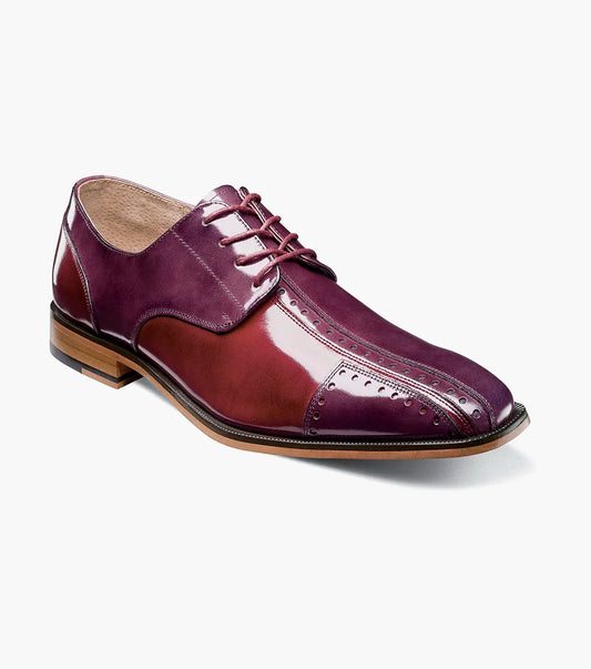 The STACY ADAMS Palmento Modified Cap Toe Oxford in Burgundy Multi (25740-641) features a polished leather upper, brogue accents, lace-up closure, Memory Foam insole, and wooden sole. Single shoe shown on white background.