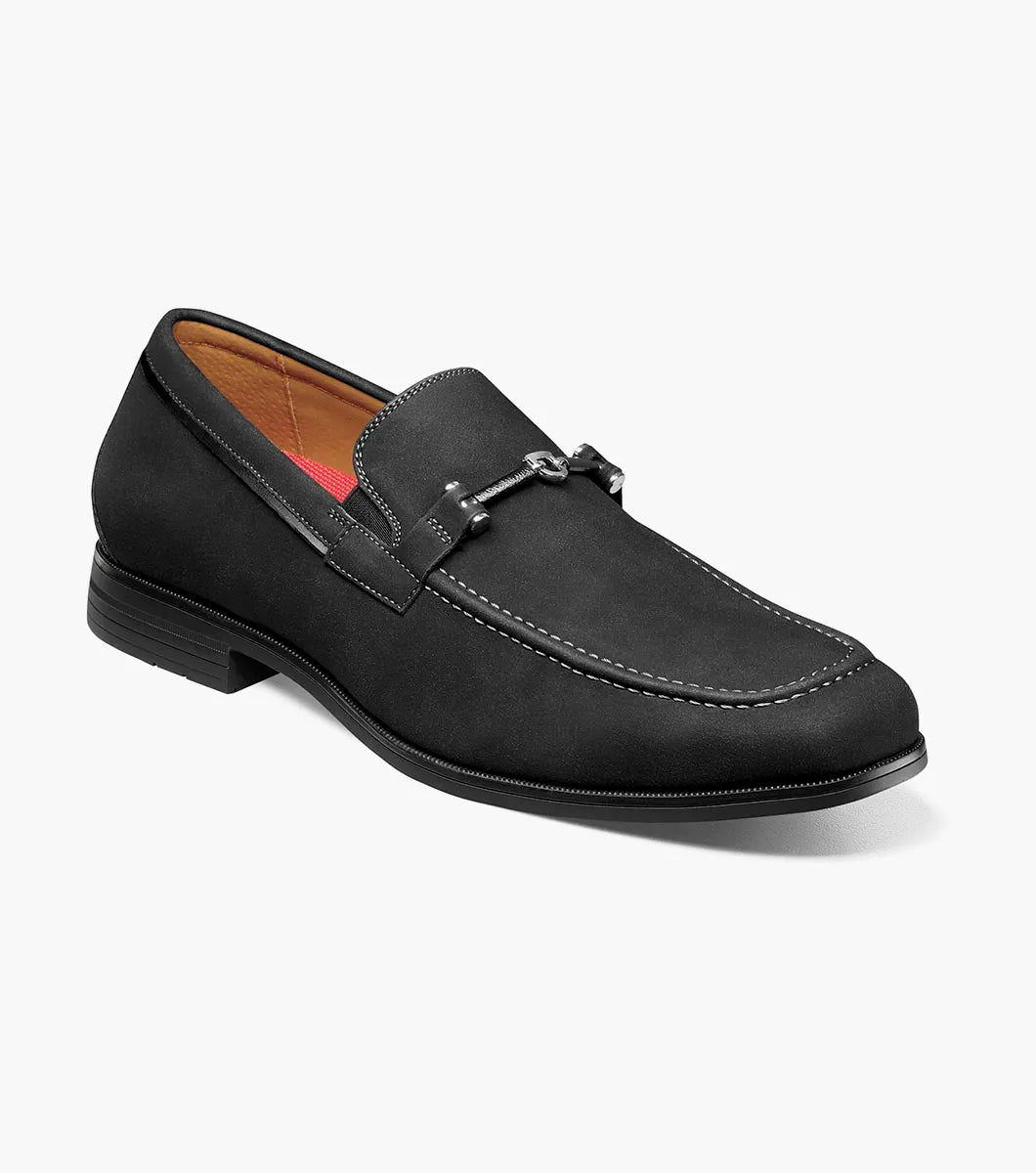 The STACY ADAMS Richardson Moc Toe Bit Slip On (25746-001) features black suede, white stitching, a metal bit detail, low heel, and cushioned RedZone footbed—all shown on a plain white background.