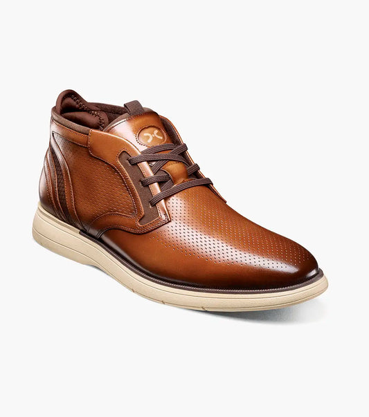 The Stacy Adams Eastmont Plain Toe Elastic Lace Chukka Boot in cognac features a perforated design, light tan rubber sole, and anatomical arch support for all-day comfort, shown on a white background.