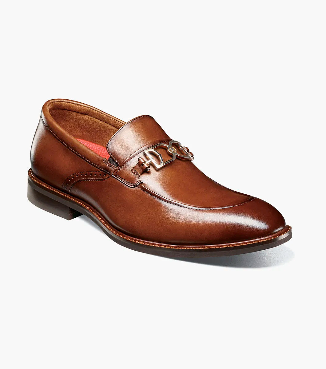 The Stacy Adams Boyd Moc Toe Bit Slip On in Brandy features a brown leather upper, moc toe design, metal horsebit detail, low heel, cushioned footbed, and visible stitching. Model 25753-226 by STACY ADAMS shown on a white background.