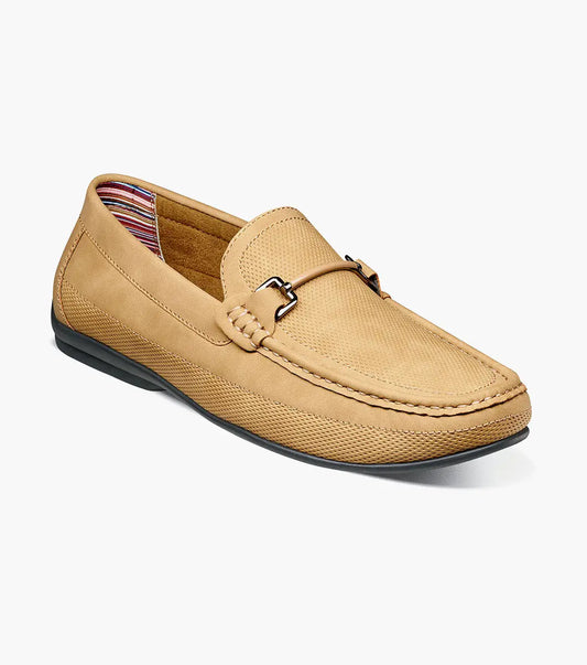 The Stacy Adams Colton Moc Toe Bit Slip On in khaki features a stitched moc toe, metal bit detail, black rubber sole, multicolored striped lining, and cushioned footbed for all-day comfort.