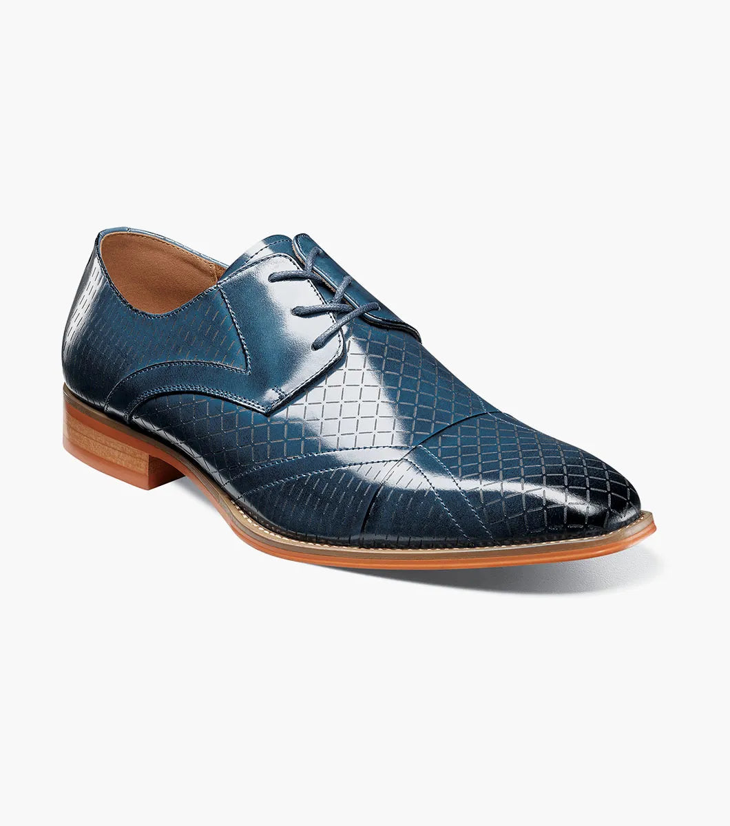 The Stacy Adams Hobson Cap Toe Oxford (25764-400) is a single blue dress shoe with a laser-etched diamond calf leather pattern, lace-up closure, brown sole, and sleek pointed toe.