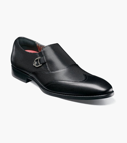 The STACY ADAMS Lockwood Wingtip Ornament Slip On in black (25767-001) features a textured upper, wingtip design, and is displayed on a white background.
