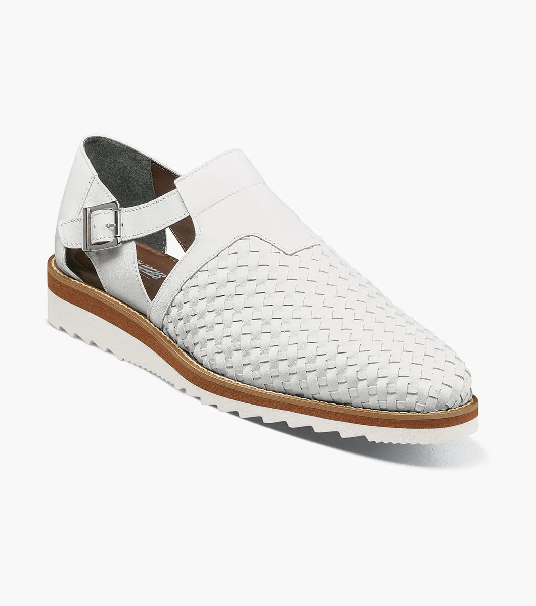 The Stacy Adams Alvarado Woven City Sandal in white features a woven leather upper, buckle strap, brown sole, white serrated outsole, and a soft memory foam insole for comfort. Displayed on a white background.