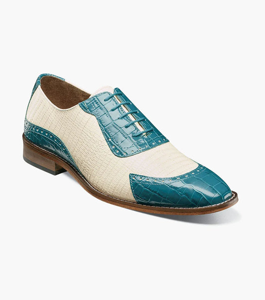 The STACY ADAMS Tarango Modified Cap Toe Oxford (25770-448) is a men's formal shoe in navy with teal, showcasing crocodile print leather and a laceless design, pictured on a plain white background.