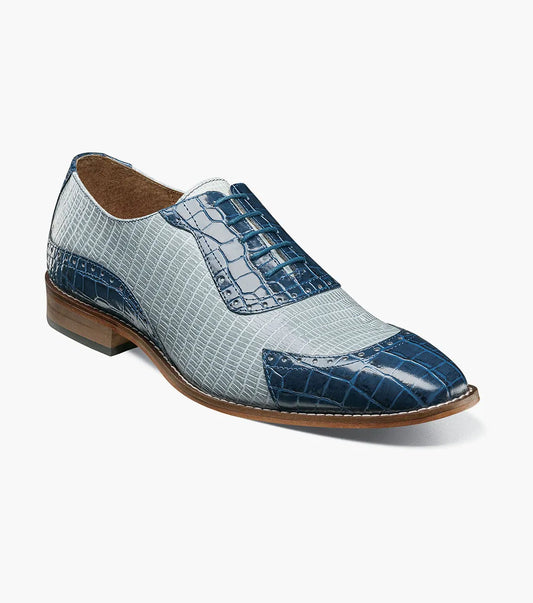The Stacy Adams Tarango Modified Cap Toe Oxford in Dark Blue Multi features pointed toes, gray and blue crocodile print leather, and a low wooden heel—ideal for formal shoe enthusiasts.
