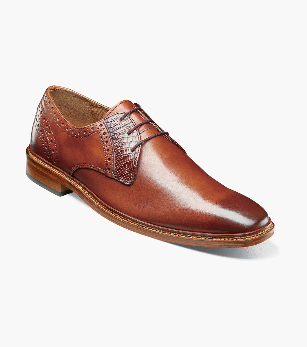 The Stacy Adams Giorgetti Plain Toe Oxford in Cognac features lizard print leather, brogue details, textured accents, a cushioned footbed, low heel, and lace-up closure.