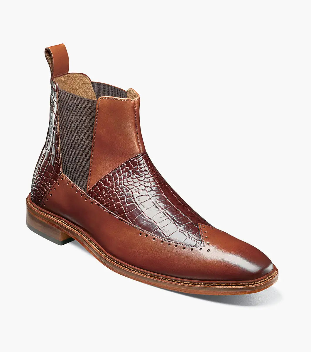The Stacy Adams Garza Wingtip Chelsea Boot in Cognac features crocodile texture detail, elastic side panel, heel pull tab, cushioned footbed for comfort, and a low wooden sole.