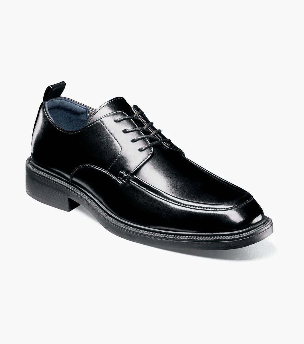 The STACY ADAMS Evan Moc Toe Oxford (Black, 25789-001) is shown as a single men’s dress shoe with a black leather upper, lace-up closure, low heel, and smooth polished finish on a plain white background. Designed for both style and comfort, it features a supportive Memory Foam footbed.