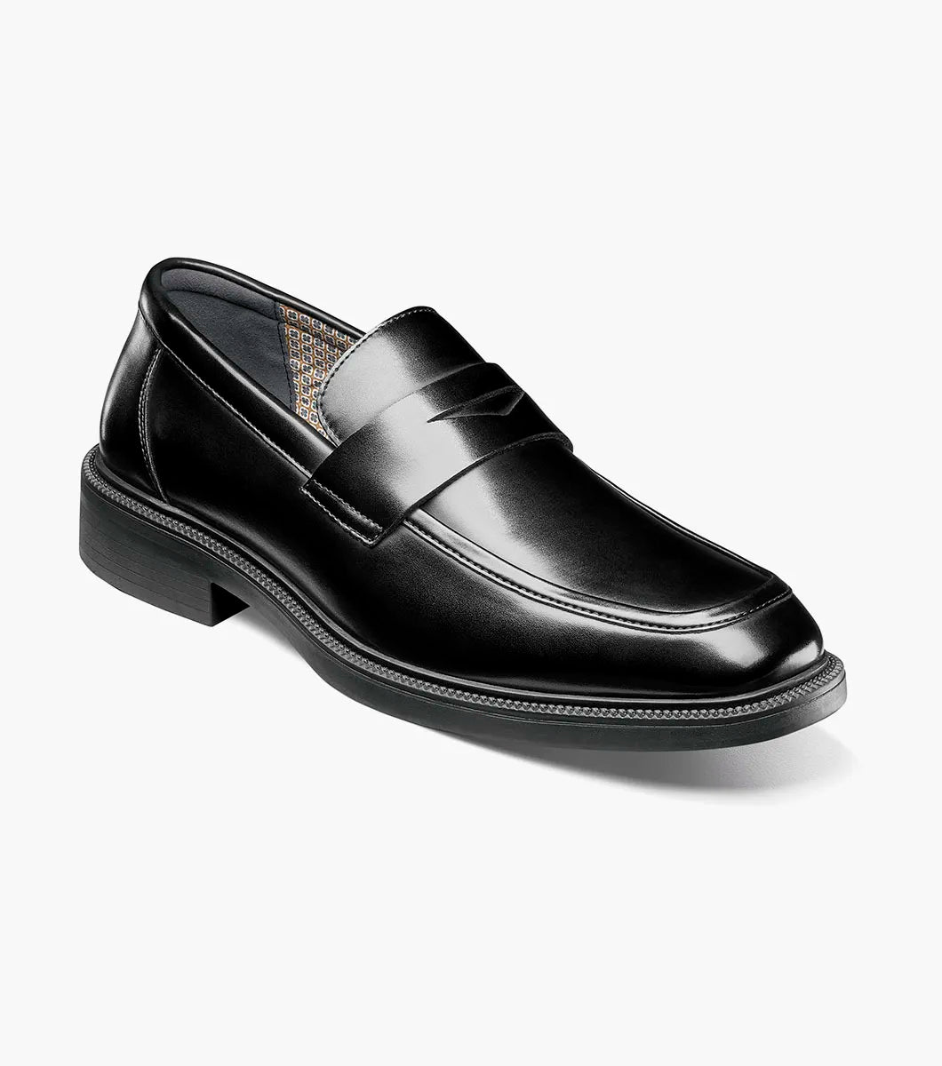 The STACY ADAMS Everett Moc Toe Penny Slip On (style 25790-001) is a single black leather loafer featuring a low heel, polished finish, moc toe stitching detail, and a cushioned insole for enhanced comfort, shown against a plain white background.