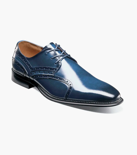 The Stacy Adams Alexander Plain Toe Oxford in Cobalt (style 25791-435) is a single shiny navy blue calf leather dress shoe by STACY ADAMS, featuring decorative perforations, laces, a memory foam insole, and a black sole, displayed against a white background.