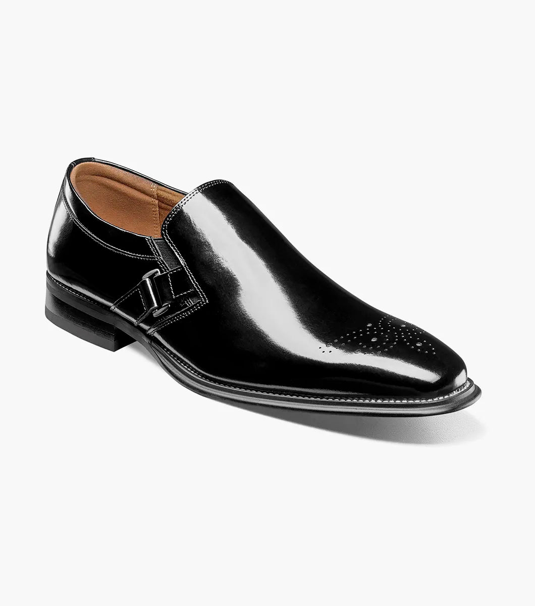 The Stacy Adams Alistair Plain Toe Ornament Slip On in black showcases a sleek leather design with a square toe, decorative stitching on the upper, and an eye-catching side buckle detail. This stylish shoe also features a comfortable memory foam insole and is displayed on a white background.