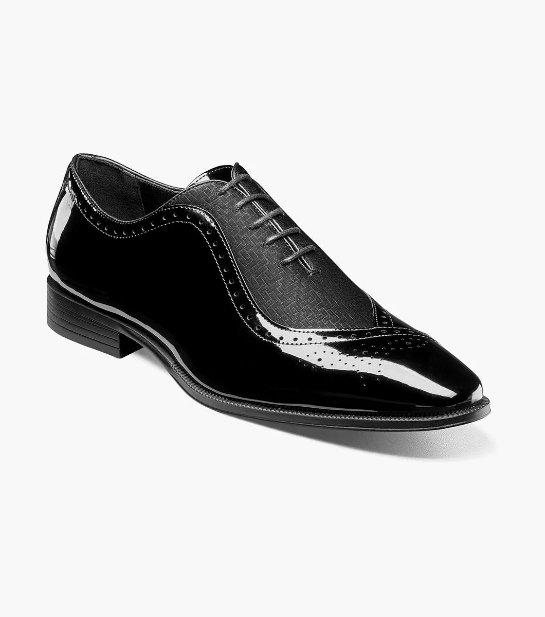 A single STACY ADAMS Stuart Folded Vamp Balmoral Oxford dress shoe in black patent leather (Style 25794-001), featuring laces, a low heel, decorative stitching, and a comfortable Memory Foam insole, is displayed on a plain white background.