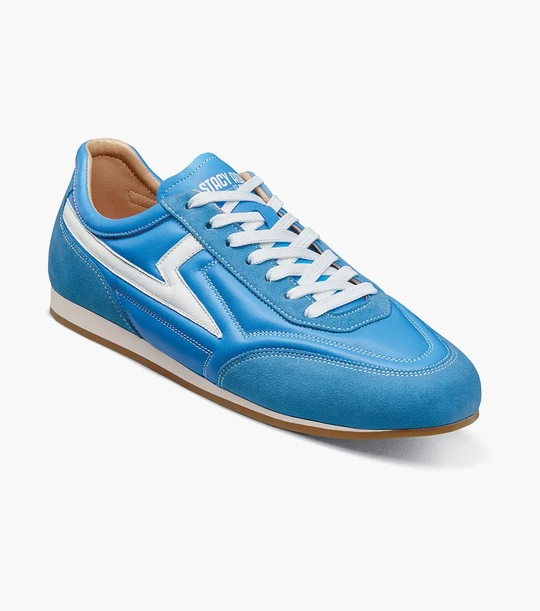 The STACY ADAMS Action 150 Sporty Lace Up in blue (style 25797-400) features white accents, white laces, and a suede toe. This low-top sneaker is showcased against a plain white background.