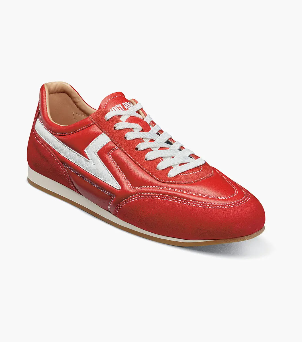 Introducing the STACY ADAMS Action 150 Sporty Lace Up in red (style 25797-600), a modern sneaker highlighted by sporty white laces and a distinctive white zigzag pattern along the side, displayed against a plain white background. The cushioned footbed provides comfort with every step.