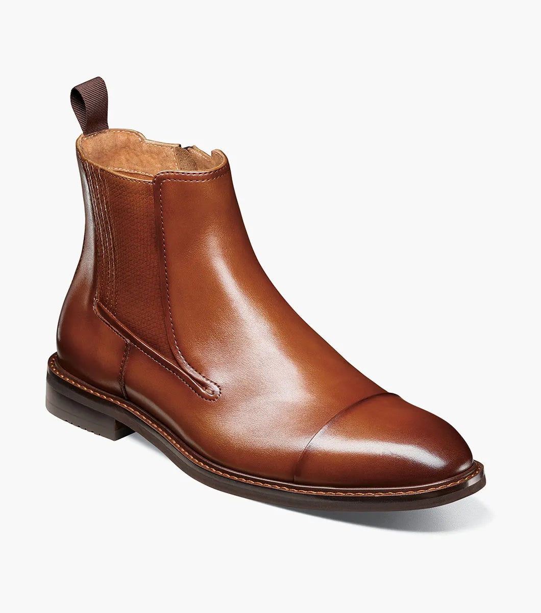 The Stacy Adams Berkshire Cap Toe Side Zip Boot in Brandy features a burnished brown leather upper, rounded cap toe, low heel, stitched detailing on the sole and toe, and is finished with an elastic side panel and back pull tab.