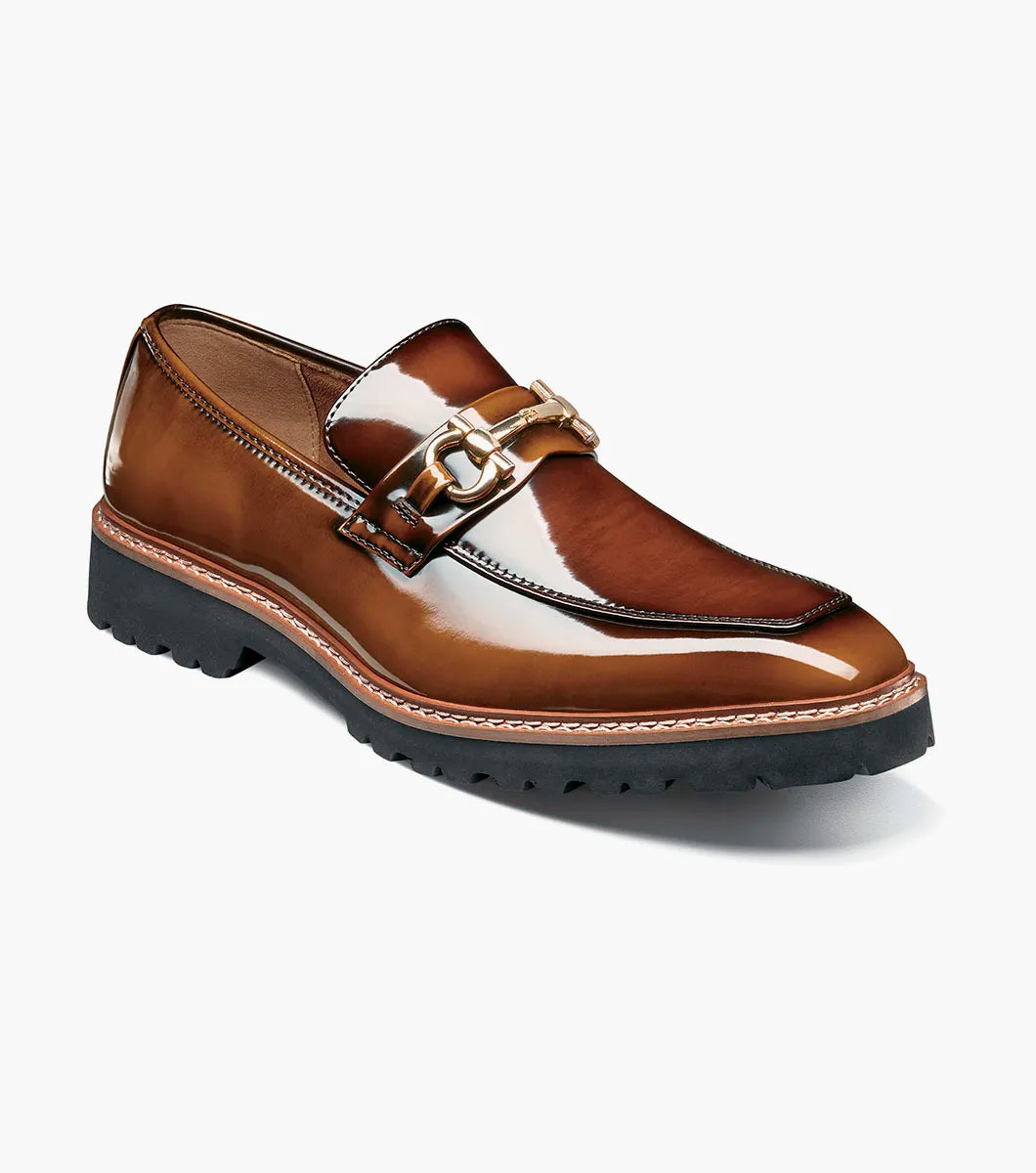Introducing the Stacy Adams Carabello Moc Toe Bit Slip On in Brown Multi (style 25804-249), this loafer features brown leather with a shiny finish, a gold metal bit detail on the front, contrast stitching, and a black rubber sole. Designed by STACY ADAMS, it offers all-day comfort thanks to its cushioned Memory Foam insole.
