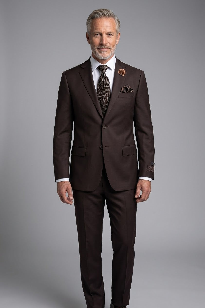 The Tiglio Luxe Novello Brown Pure Wool Men’s Suit TIG1003 features a dark brown European-style single-button jacket, matching trousers, white shirt, patterned tie, pocket square, and lapel pin—modern menswear displayed on a headless mannequin.