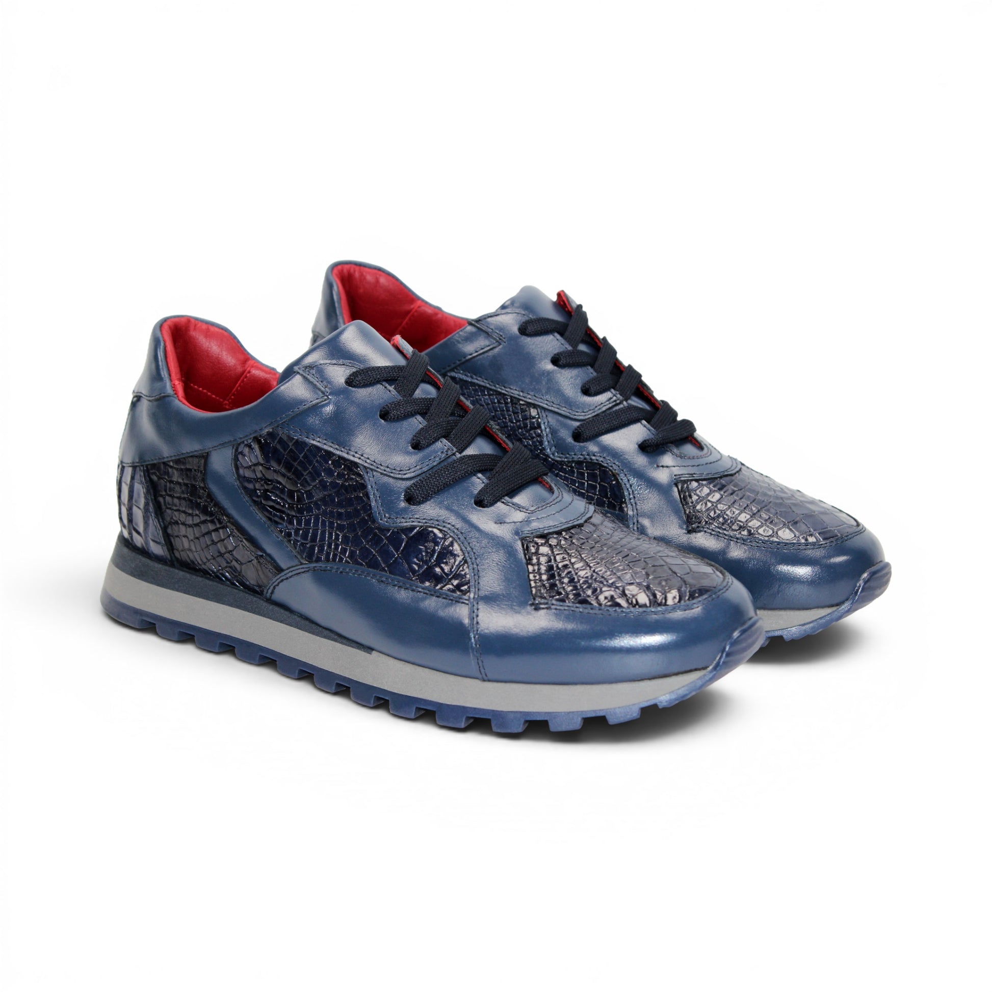 The Fennix 3538 Navy by Fennix of Italy features textured, crocodile-inspired navy blue panels, black laces, a red interior lining, and a grey sole. Shown in side profile against a white background, this sneaker exemplifies Italian craftsmanship and embodies the allure of exotic luxury footwear.