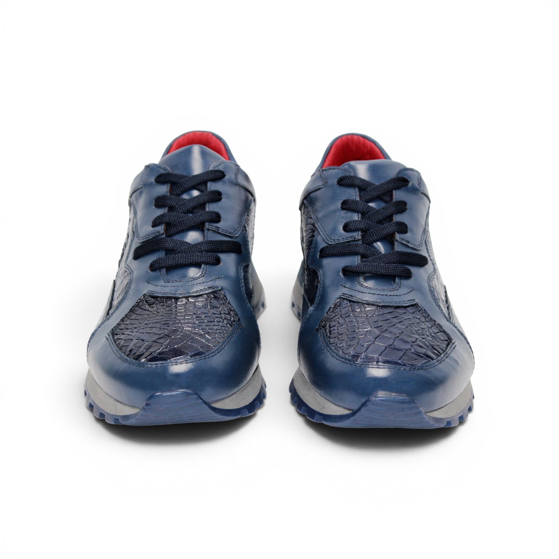 The Fennix 3538 Navy by Fennix of Italy features textured, crocodile-inspired navy blue panels, black laces, a red interior lining, and a grey sole. Shown in side profile against a white background, this sneaker exemplifies Italian craftsmanship and embodies the allure of exotic luxury footwear.