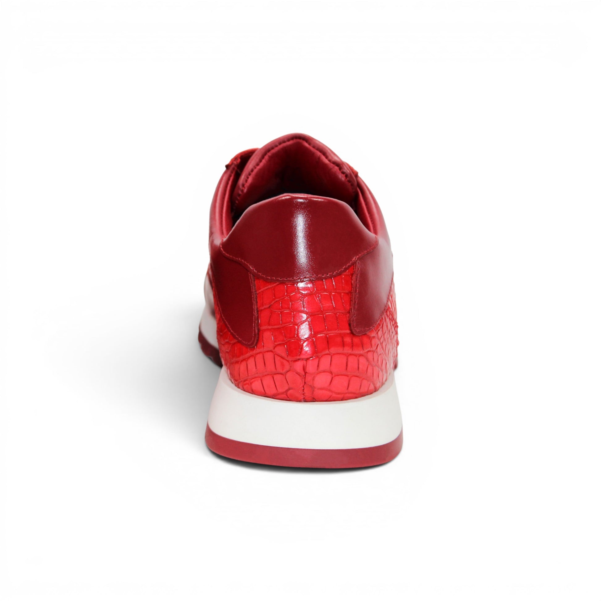 The Fennix 3538 Red by Fennix of Italy is a red athletic sneaker featuring a textured surface reminiscent of exotic leather, matching red laces, and a white midsole paired with a red outsole, displayed in profile view. Its expert craftsmanship provides a subtle nod to luxury Italian footwear, seamlessly blending style and sport in one sleek design.