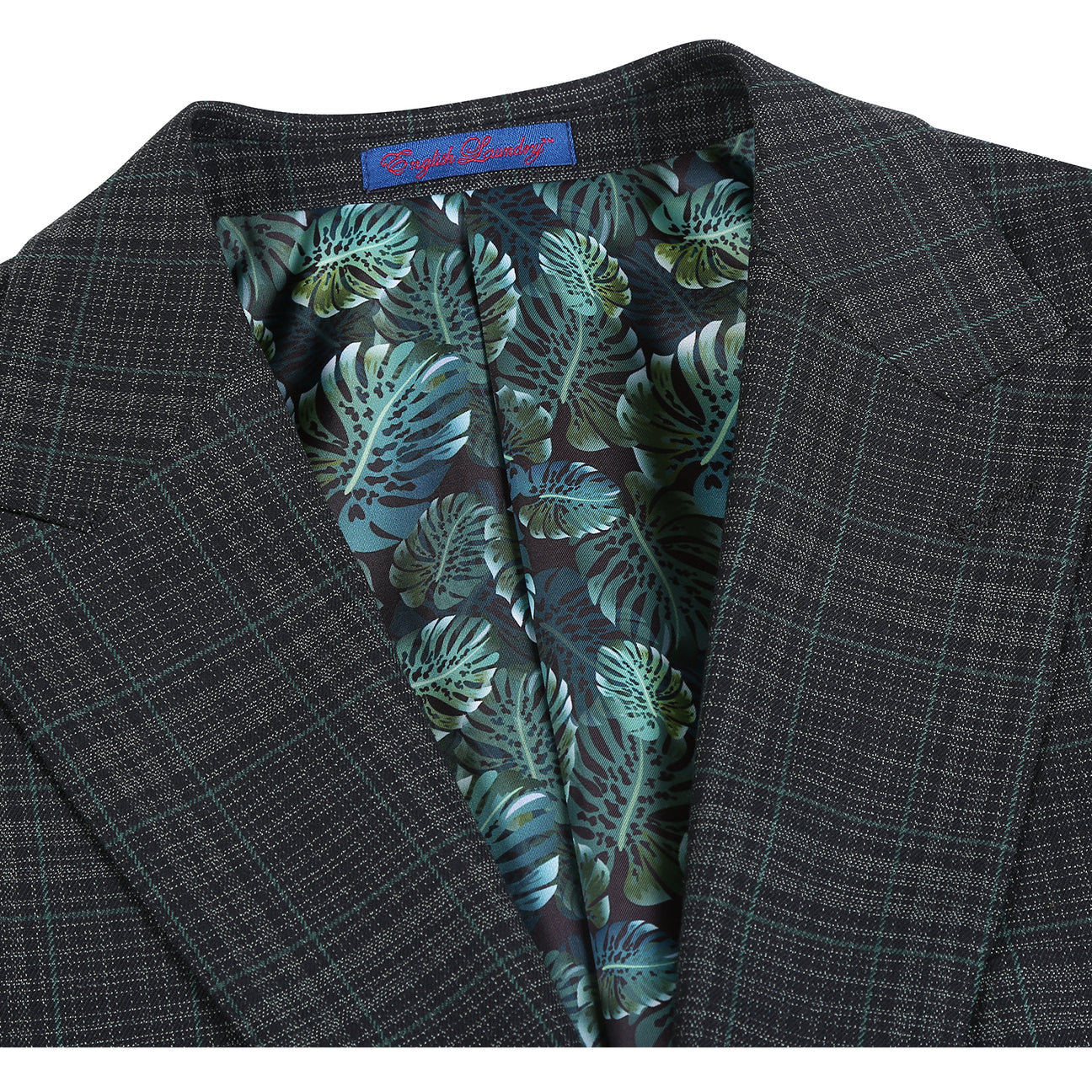 The ENGLISH LAUNDRY 2pc Suit Green 32-24-001EL by English Laundry is a dark plaid men's blazer featuring notch lapels, two-button closure, flap pockets, and a green tropical leaf print lining.