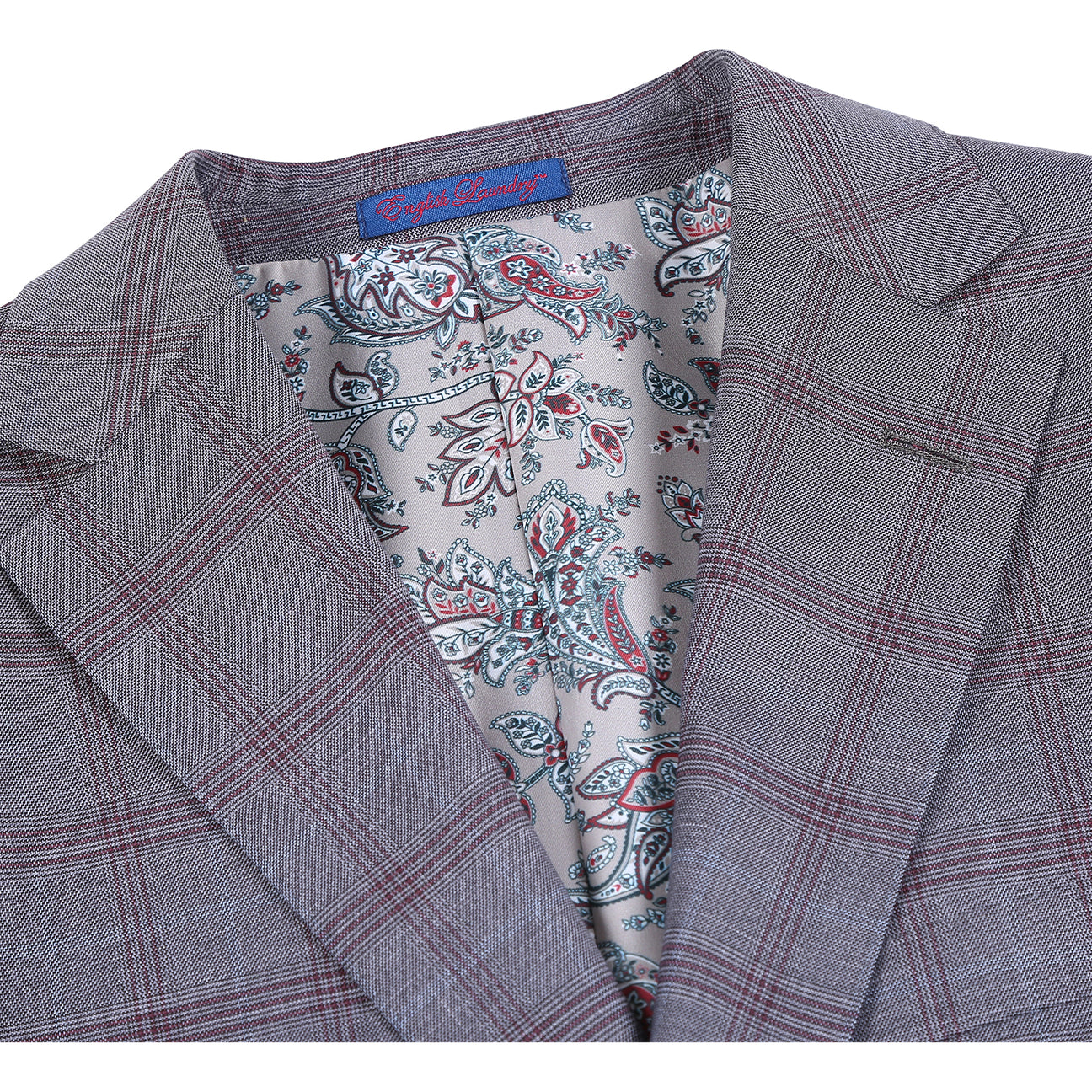 A man models the ENGLISH LAUNDRY 2pc Suit by English Laundry, featuring a gray plaid design with patterned inner lining. Close-ups highlight the fabric, buttons, and lining. Text notes its comfy polyester-rayon blend for style and ease.