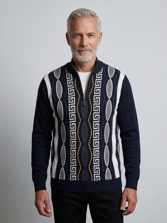 A man with gray hair and a beard wears the Suslo Couture Half Zip Sweater FP207 by Unique Design Menswear, a navy geometric knit sweater with a zip-up design, while standing against a plain light background.