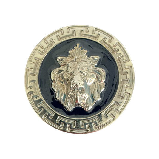A round metallic pin inspired by the Matiste Navy/Silver Belt Buckle 40mm B40 features a raised lion head at the center, set against a black background with a patterned border, reflecting Matiste's iconic luxury style.
