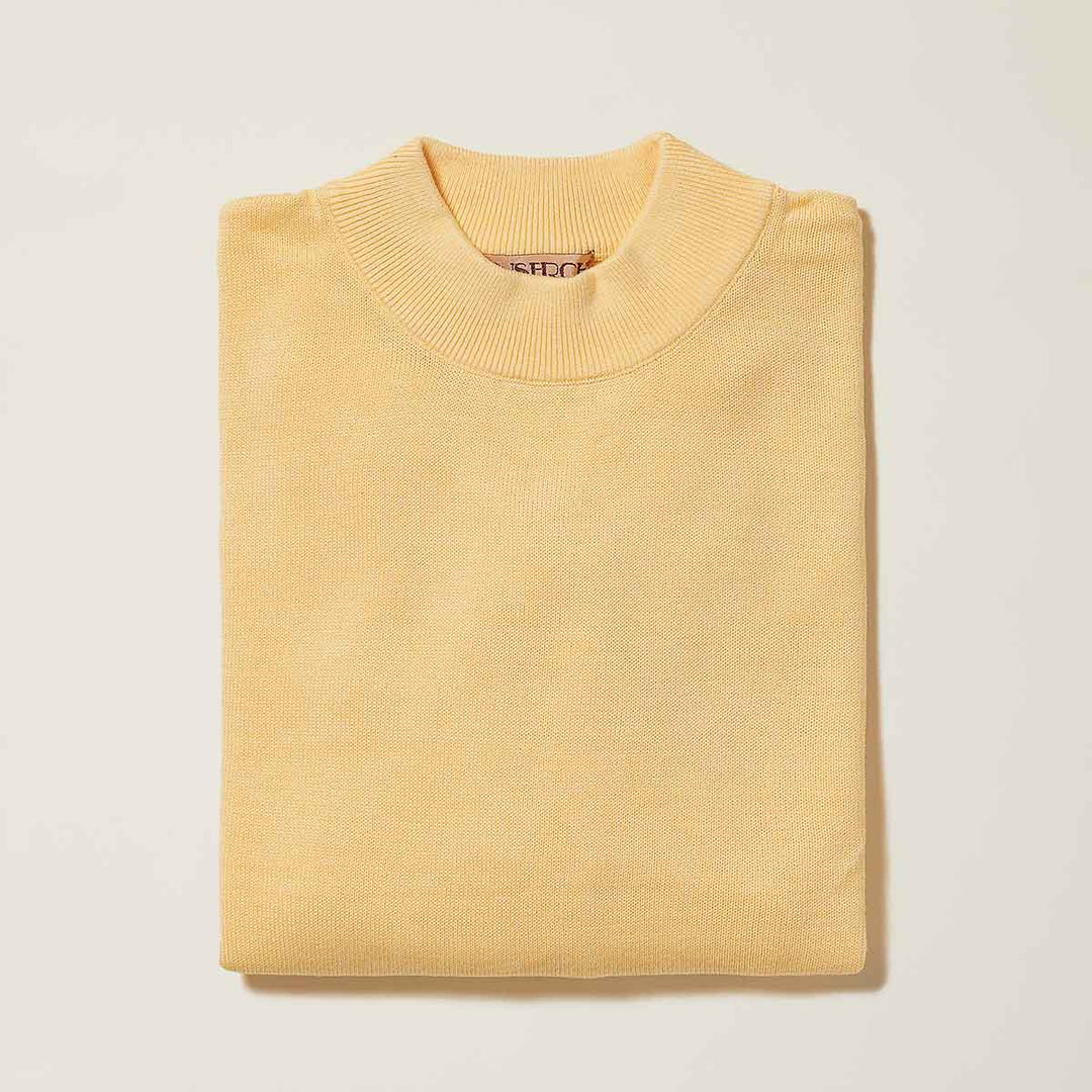 The Inserch Cotton Blend Mock Neck Sweater in Banana Cream (4308-00145) is folded and laid flat on a plain, off-white background.