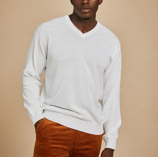 A man wears the Inserch Cotton Blend V-Neck Sweater 4608-00002 in white and rust corduroy pants, standing against a plain beige background.