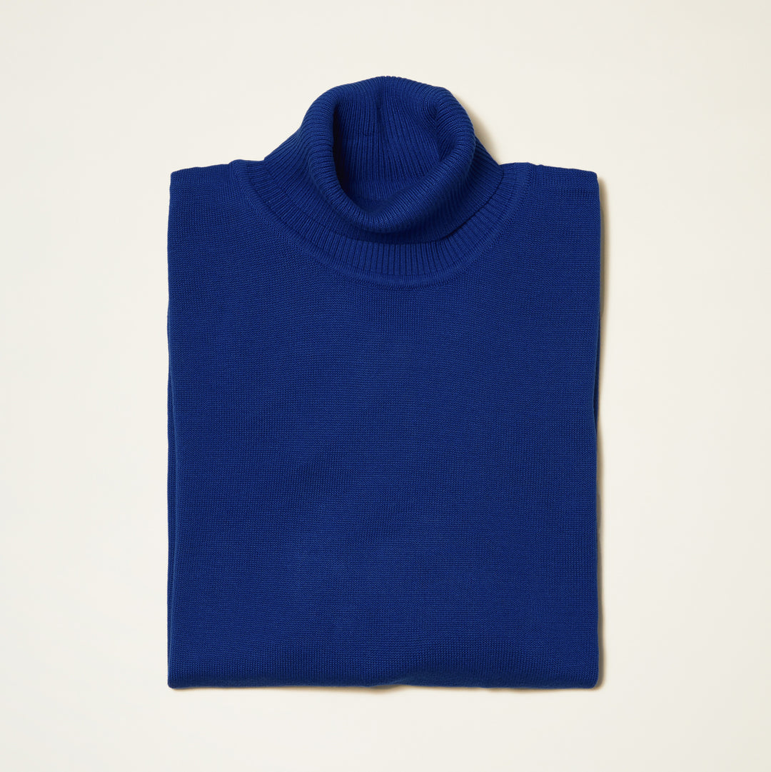 The Inserch Cotton Blend Slim Fit Turtleneck Sweater in River Blue (style 4808) by Inserch is neatly folded and displayed on a light-colored surface.