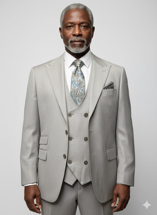 An older man with gray hair and beard models the Tiglio Luxe Prosecco Light Taupe Birdseye Modern Fit TL4128 suit by Tiglio Luxe, standing against a plain light background—showcasing refined, modern men's tailoring.