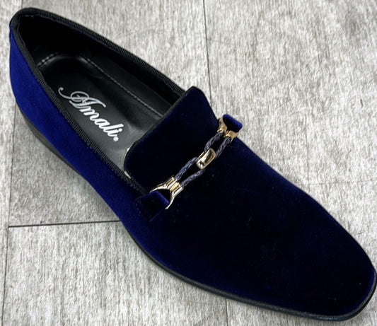 An exquisite dark purple velvet loafer with a gold chain detail, crafted from genuine leather by UNIQUE DESIGN MENSWEAR, rests elegantly on a gray tiled floor.