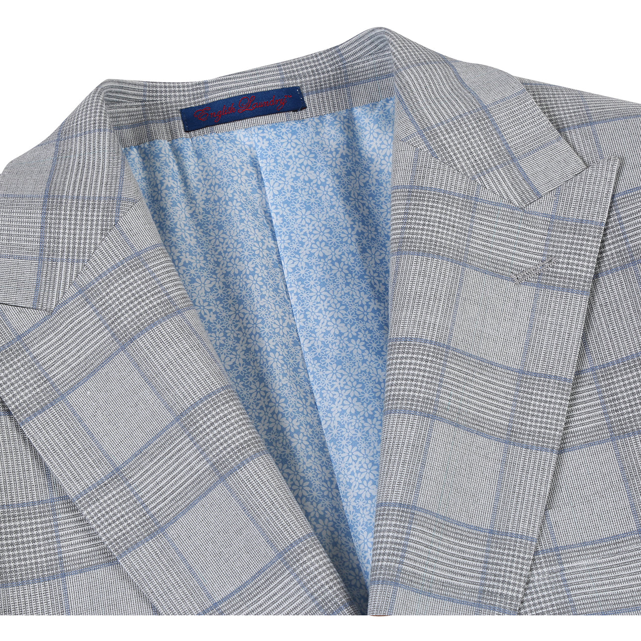 The English Laundry ENGLISH LAUNDRY TR Suit 12-66-092EL slim fit light gray plaid jacket, with a two-button closure, is displayed on a mannequin, paired with a white dress shirt and dark gray tie.