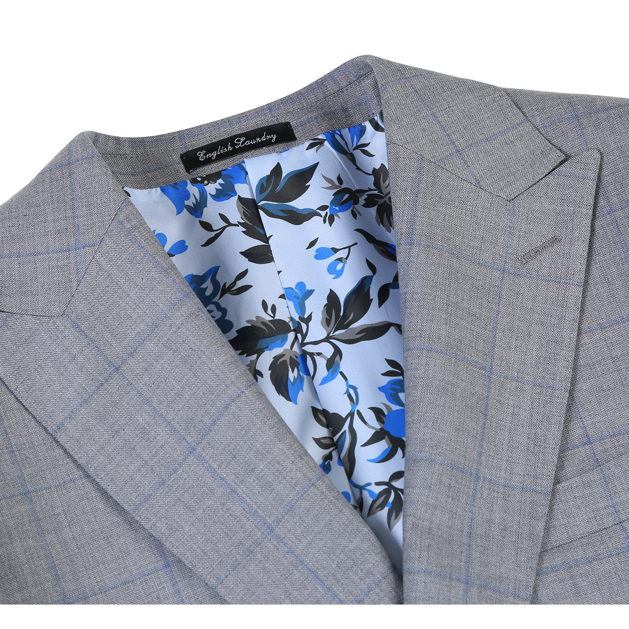 The ENGLISH LAUNDRY Wool Suit EL92-55-092 by English Laundry is a gray plaid wool slim-fit jacket with notch lapels, two buttons, and flap pockets, displayed over a white shirt and blue tie on a mannequin.