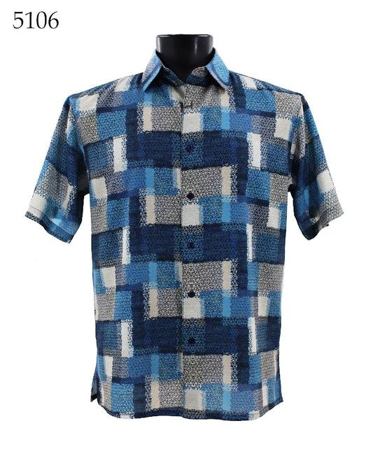 The Bassiri Short Sleeve Shirt 5106 features a sophisticated blue, gray, and beige geometric pattern. It is elegantly displayed on a black mannequin torso with the label "5106" in the top left corner.