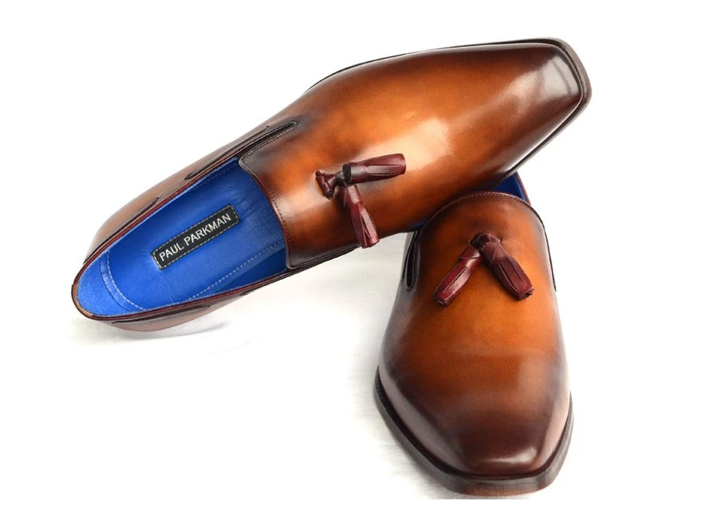 The Paul Parkman Tassel Loafer Walnut Leather Shoes (5141-WALNUT) feature Italian calfskin with a gradient brown finish, blue inner lining, and classic tassels. Displayed against a white background.