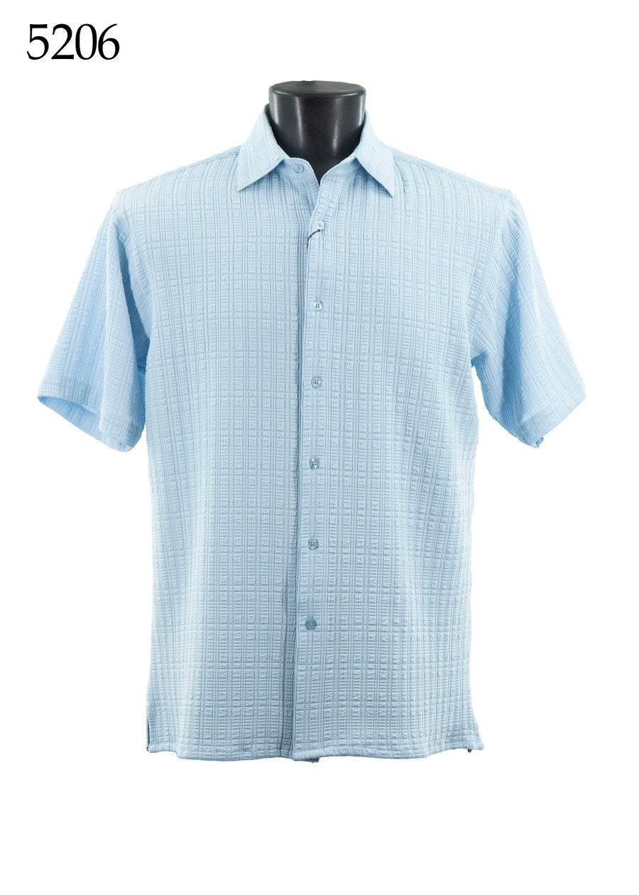 The Bassiri Short Sleeve Shirt 5206 by Bassiri is a light blue regular-fit, short-sleeve button-up with a textured checkered pattern, shown on a black mannequin. The number 5206 appears in the top left corner.