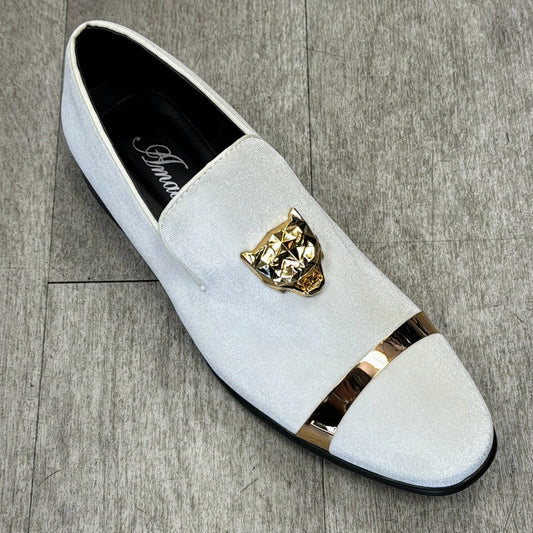 White slip-on shoe, the Exclusive Formal Dress Shoe White EARL from UNIQUE DESIGN MENSWEAR, crafted from genuine leather with a gold-toned decorative emblem and stripe on the toe, sitting on a gray wooden floor. Made in Italy for those who appreciate elegance and style.