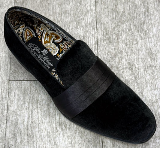 The Exclusive Formal Dress Shoe Black 7021 by UNIQUE DESIGN MENSWEAR, featuring a sleek dark band and a paisley-patterned interior crafted from genuine leather, rests on a light wooden floor.