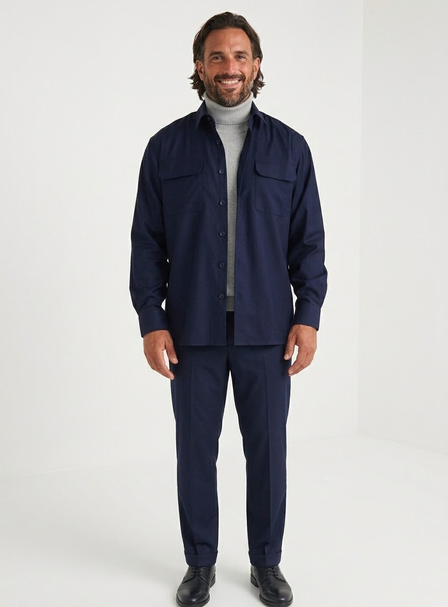 A man wearing the Inserch Two-Pocket 2pc Set SE004-00006 Ink, a navy blue regular fit shirt with two pockets by Inserch, layered over a light gray turtleneck, stands against a plain beige background.