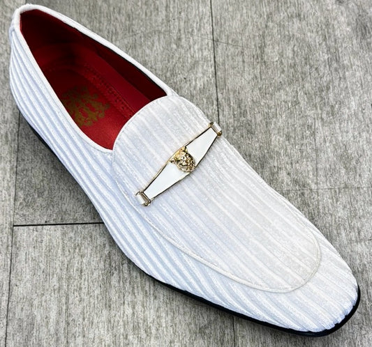 The Exclusive Formal Dress Shoe White 6946 by UNIQUE DESIGN MENSWEAR is a genuine leather loafer with a white, striped exterior adorned with a gold decorative emblem. It features a luxurious red interior and has a sleek black sole. Resting gracefully on a wooden surface, this Italian creation embodies sophistication and timeless style.