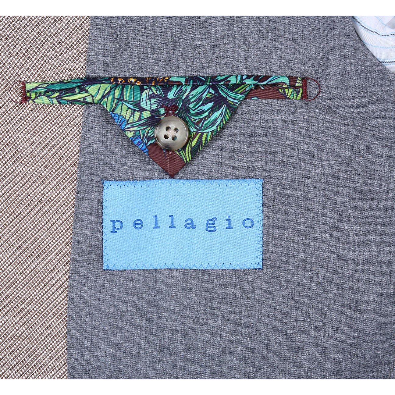 The Pellagio Camel Men's Slim Fit Riserva Jacket PS26-1 by Pellagio, in a sleek single-breasted design with two buttons, is styled on a mannequin with a white shirt, red-blue plaid tie, and green pocket square.