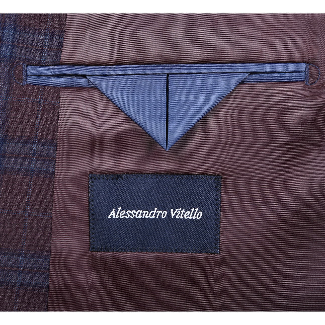 Plaid suit jacket with a purple tie and pocket square on a mannequin, with close-up details of the fabric and brand label.